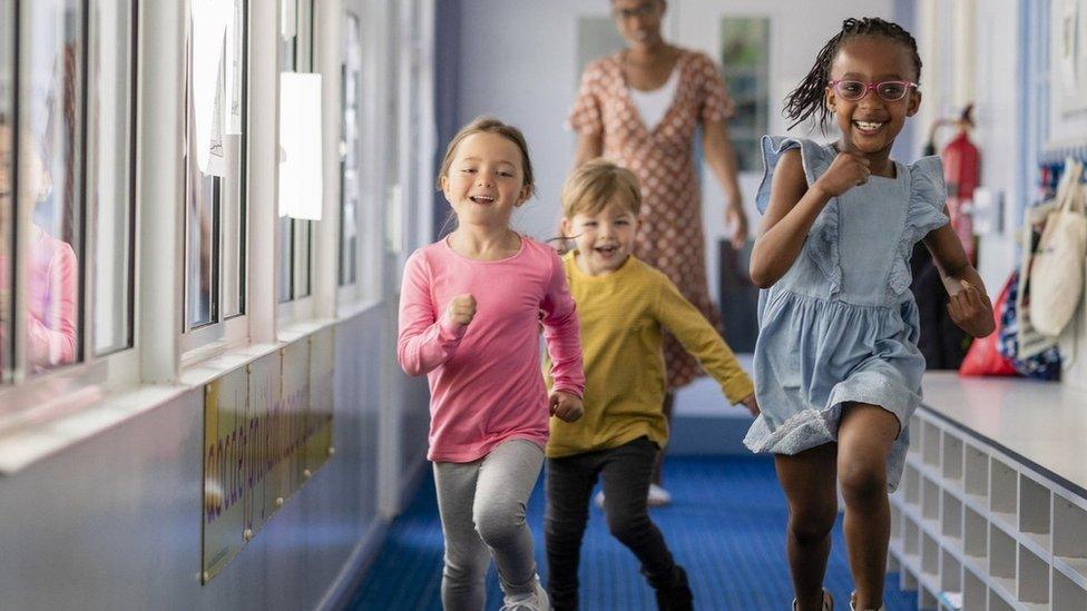 Pre-school children running through a hallway