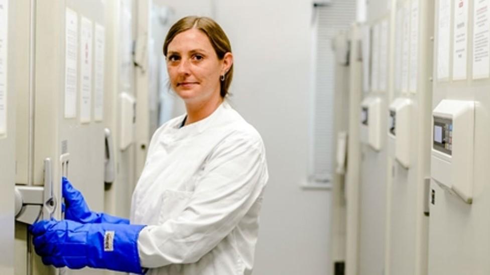 Dr Laura Palmer wearing a white uniform and blue gloves in the South West Dementia Brain Bank