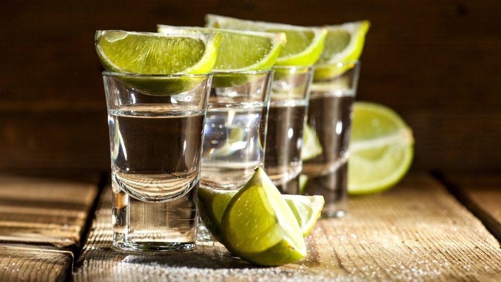 Shots of tequila with lime wedges