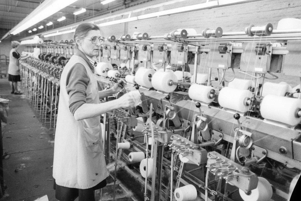 Woman working at a thread spinning machine