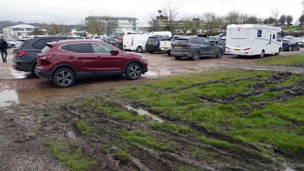 Cars at Cheltenham Festival and muddy ground