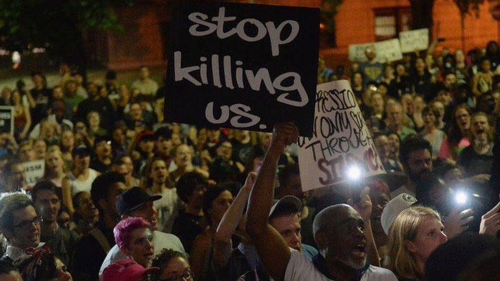 Hundreds of protestors gather holding signs including "stop killing us" in St Louis and "black lives matter"