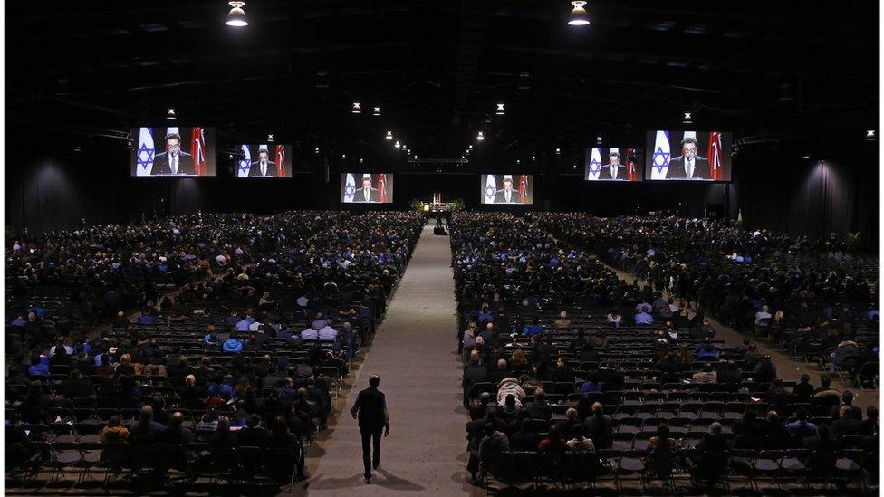 Mourners seated in the convention hall