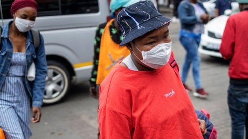 South African commuters wear masks as a preventive measure at the Wanderers taxi rank in Johannesburg CBD, on March 18, 2020.