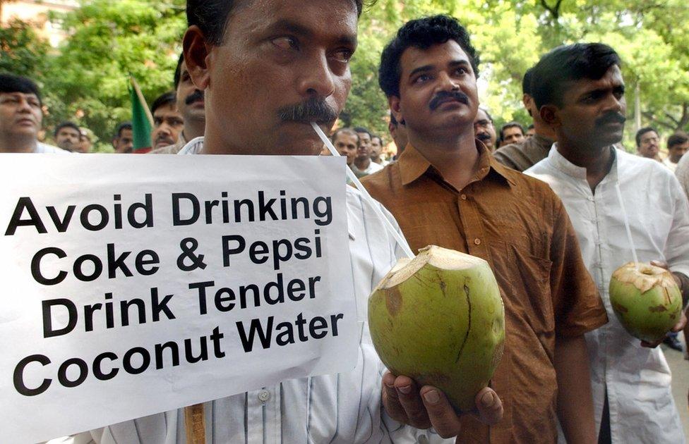 Activists of the Indian federal Democratic Party drink coconut water during a demonstration against against cola giants Pepsi and Coke in New Delhi, 21 August 2003.