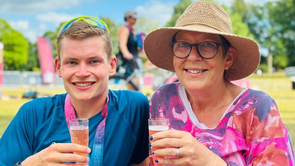 Angela Ramsell and her son Charlie outside smiling with a glass of fizz