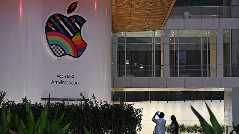 People are seen taking pictures of the soon-to-be launched Apple's first company-owned store in India inside the Jio World Drive mall at Bandra Kurla Complex (BKC) in Mumbai.