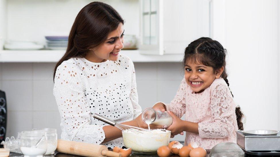 Child baking with an adult.