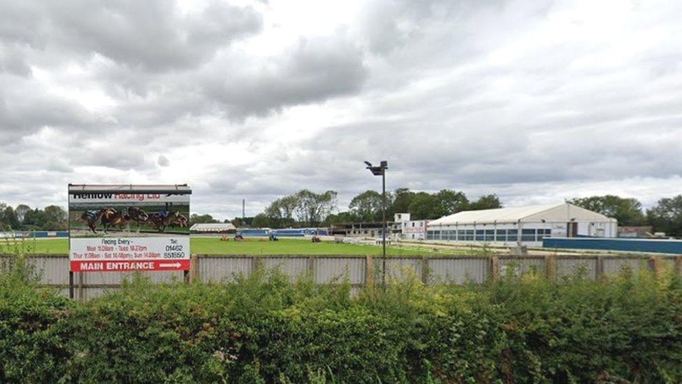 Picture of stadium showing Henlow Racing sign and white spectator building