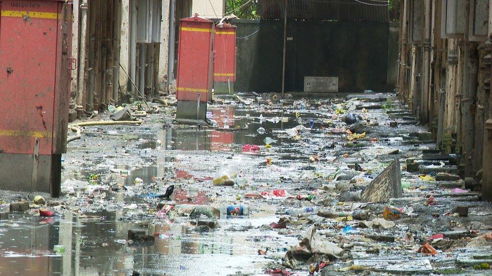 An overflowing sewer between homes in Mahul