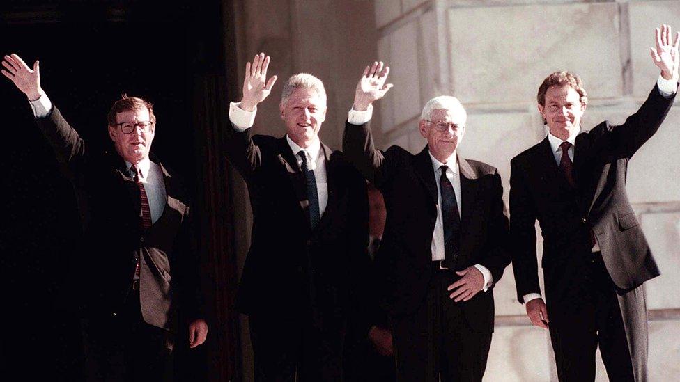 David Trimble, Bill Clinton, Seamus Mallon and Tony Blair wave on the steps of the Parliament Buildings at Stormont