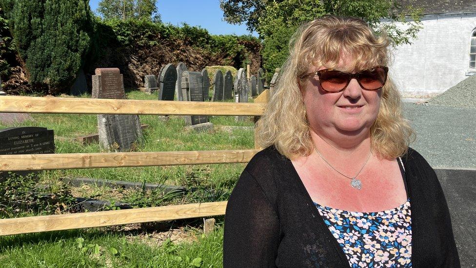 Jackie Davies standing in front of gravestones