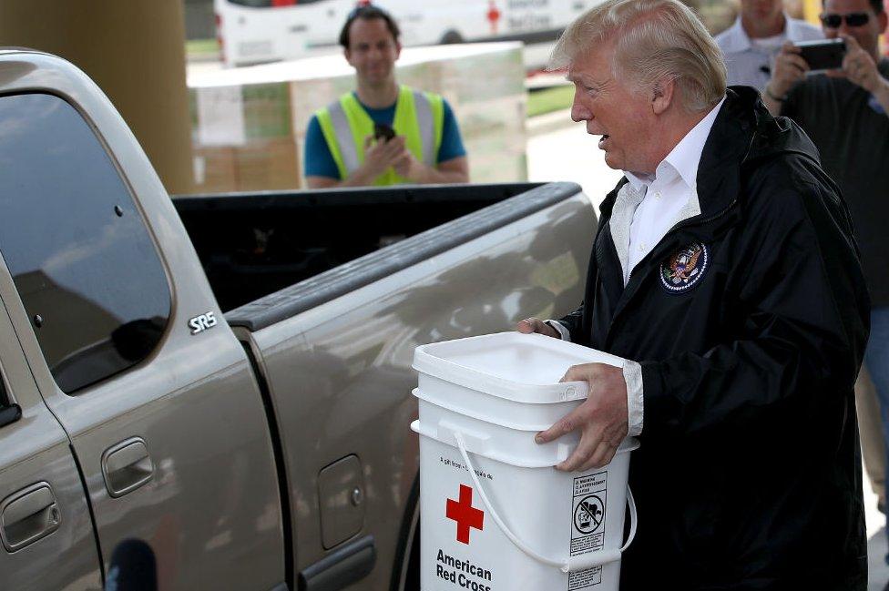 President Trump carries emergency supplies to a waiting pickup truck for residents hit by Hurricane Harvey while visiting the First Church of Pearland September 2, 2017 in Pearland, Texas