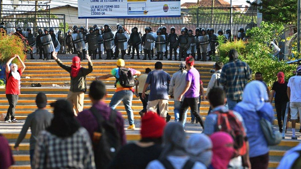 Students of the National Autonomous University of Honduras confront riot police during a protest