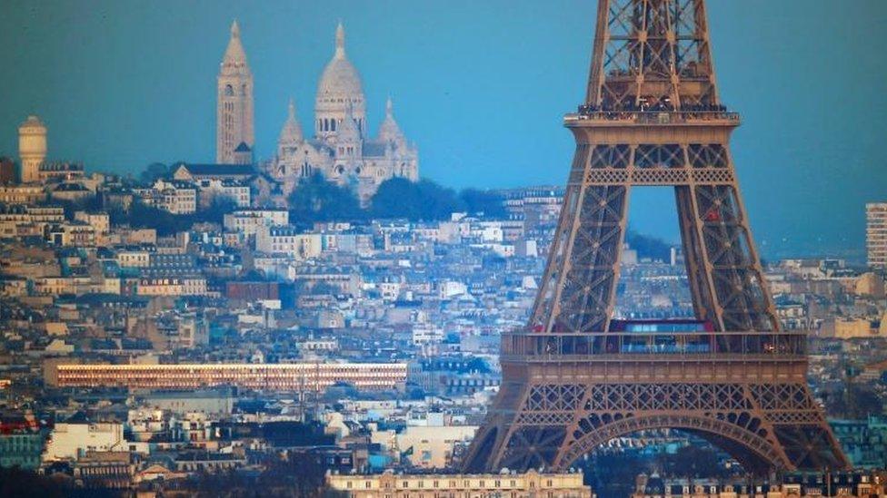 The Eiffel Tower is seen in front of the Sacre Coeur Basilica on Montmartre