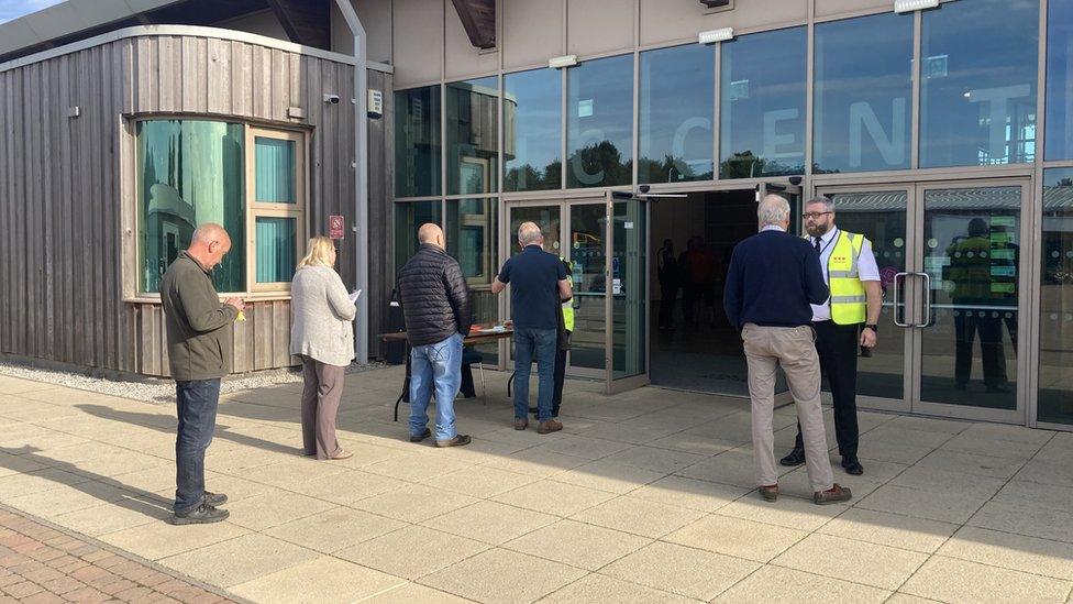 People queueing to get into meeting