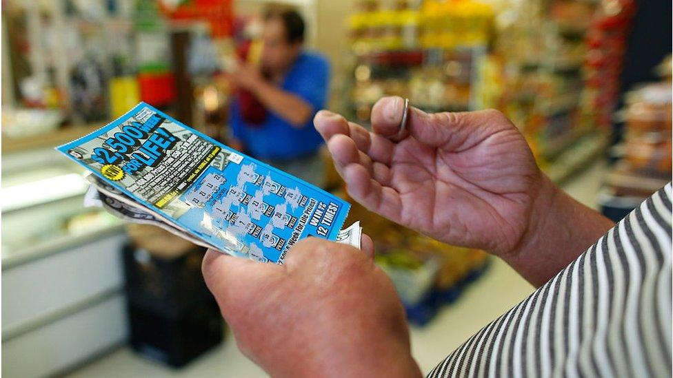 A man scratches a lottery ticket