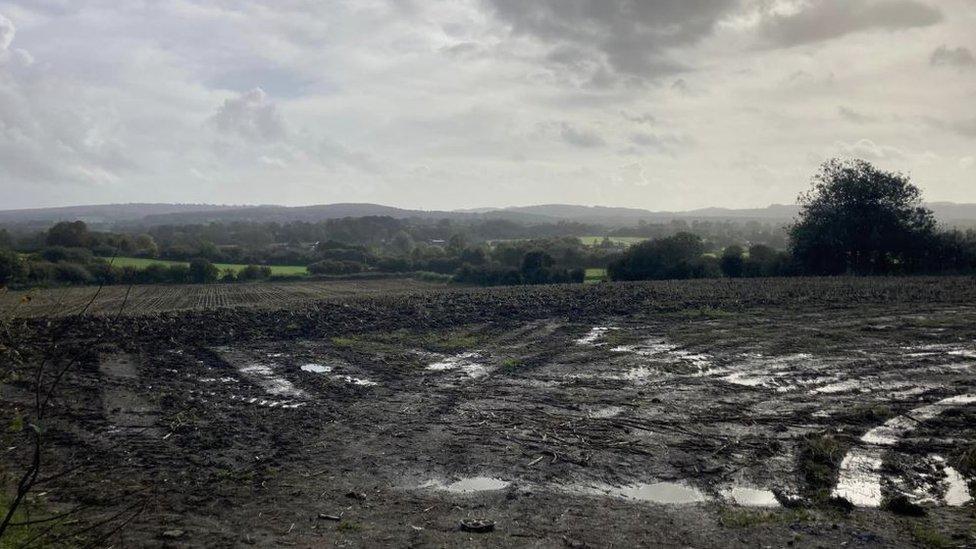 Muddy field and hills in the background