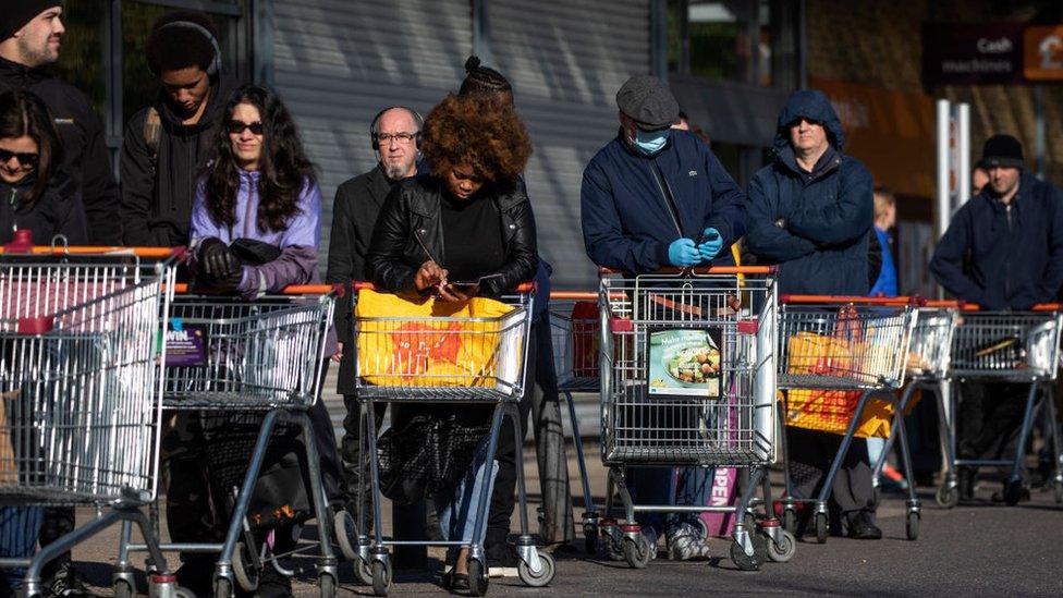 People queue outside supermarket