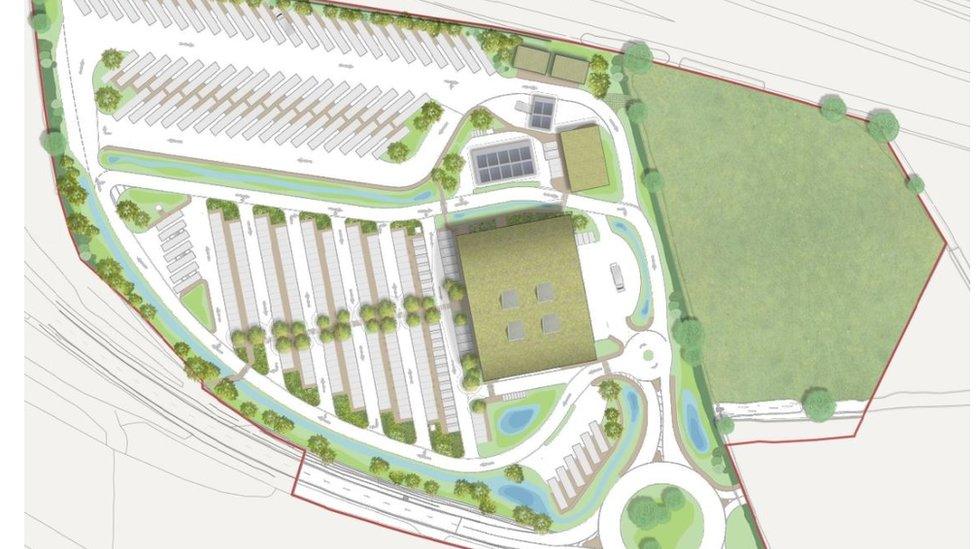 Plans for the new service station seen from above. There is lots of space for parking, there are plenty of trees around and the service station itself has a green roof