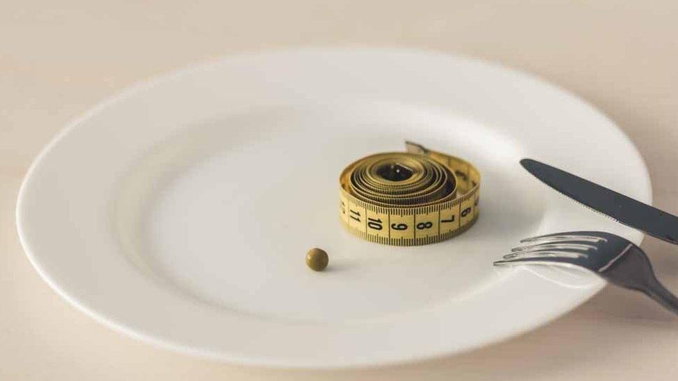 A plate with a single pea and a tape measure