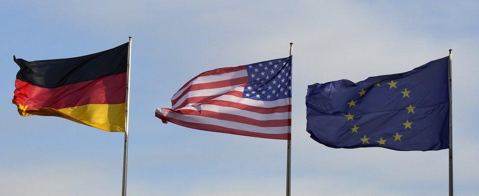 The flags of Germany (L), the US and EU flutter at the Chancellery in Berlin, where the German Chancellor met Barack Obama paying his farewell visit to the German capital on November 17, 2016.