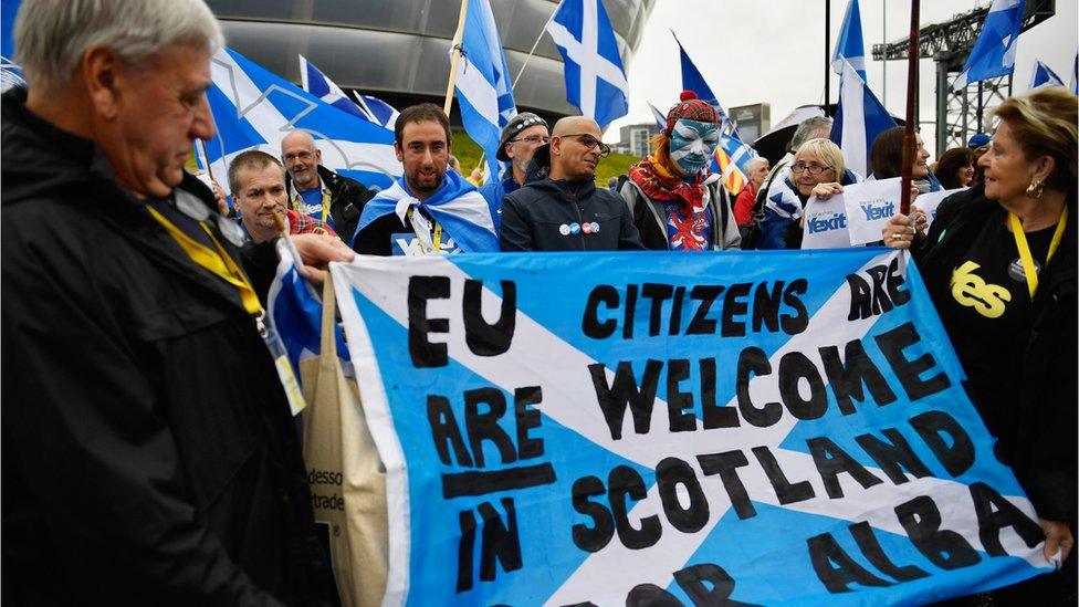 Independence supporters hold up a banner stating that EU citizens are welcome in Scotland as they take part in a rally outside the Scottish National Party conference on October 15, 2016 in Glasgow,