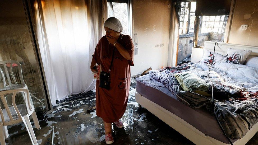 A woman stands in a damaged room after rockets were launched from the Gaza Strip, in Ashkelon, Israel October 7, 2023.