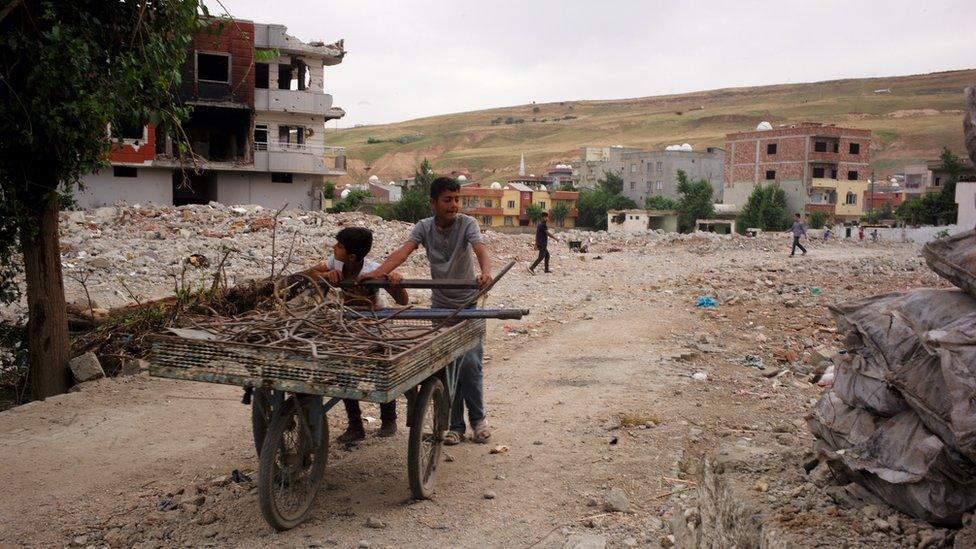 Two children wheeling wood along a street in Cizre, Turkey - May 2016