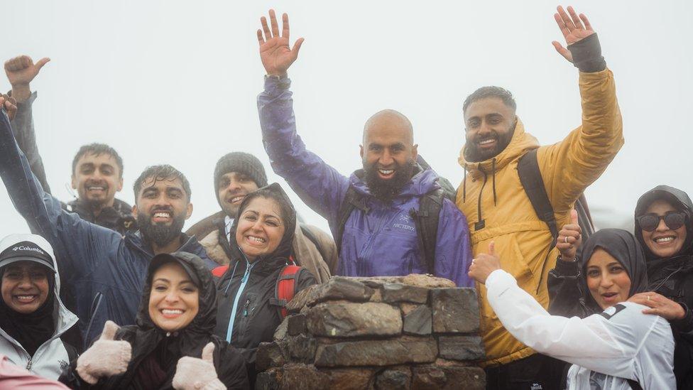 A group of walkers on top of a peak