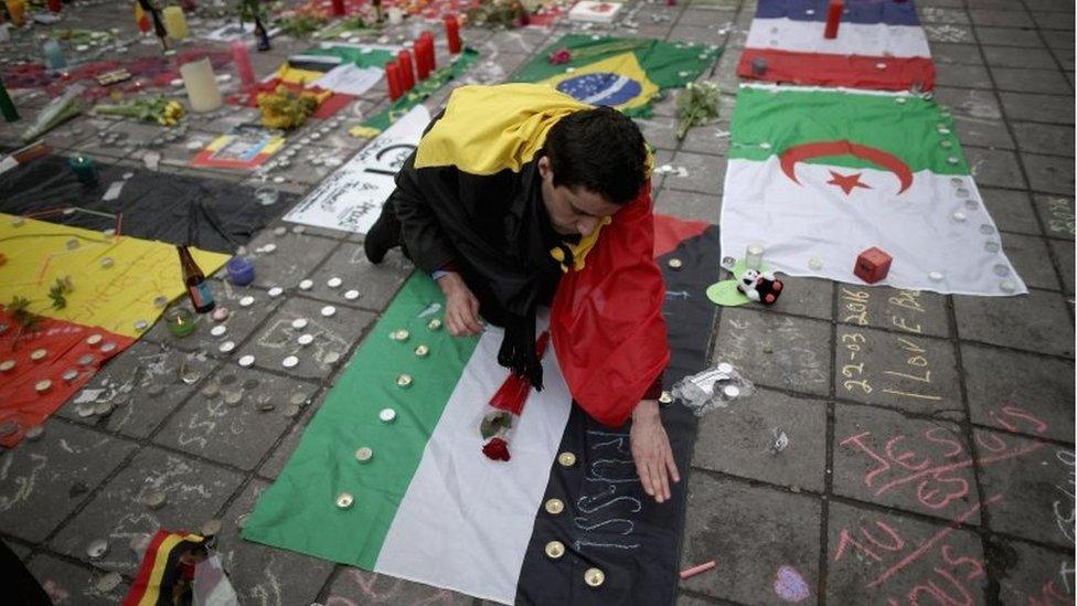 A man chalks messages of support on the square near the former bourse. Photo: 23 March 2016