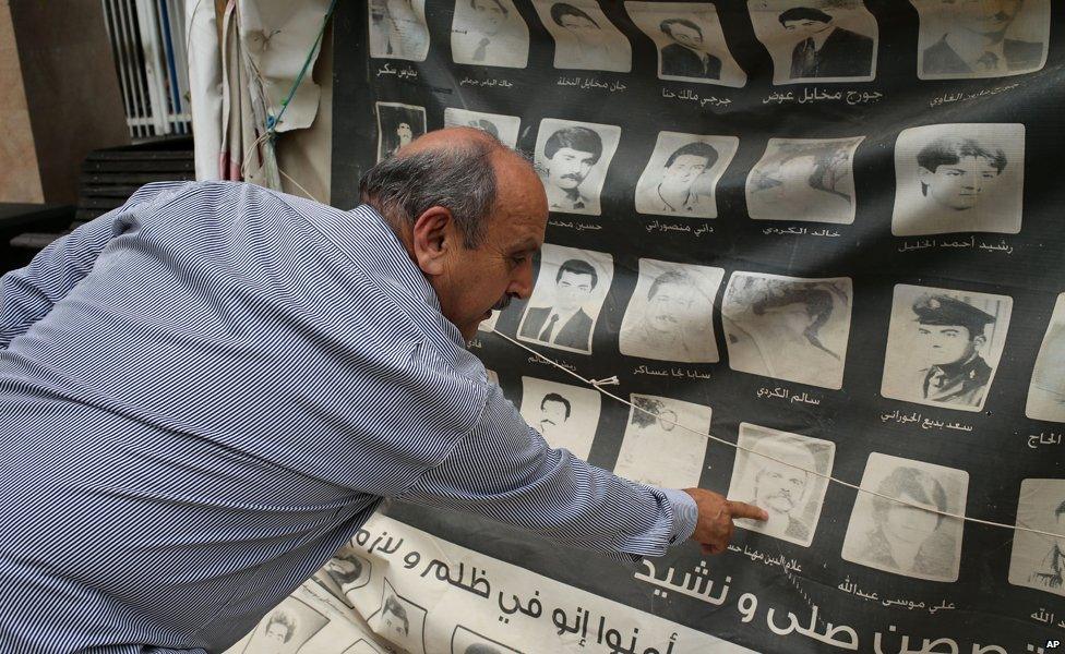 Ali Aboudehn points to a portrait of a fellow inmate who is now missing