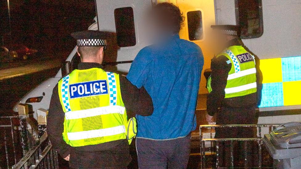 Man being arrested during a police raid