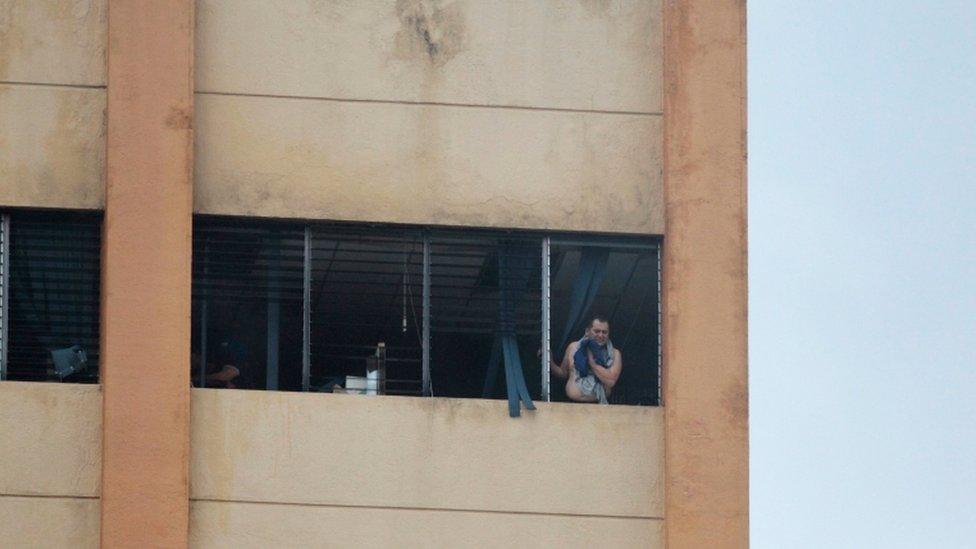 A victim waits to be evacuated at the ministry of treasury building during a blaze in San Salvador, El Salvador, July 7, 2017