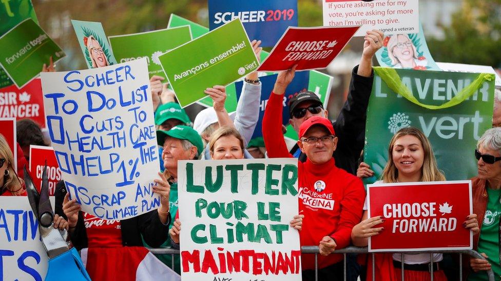 Supporters with signs seen gathered in front of the federal election debate venue