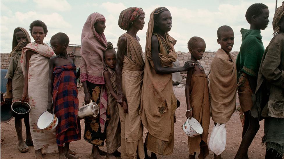 Victims of famine wait in line for food during Somalia's civil war.