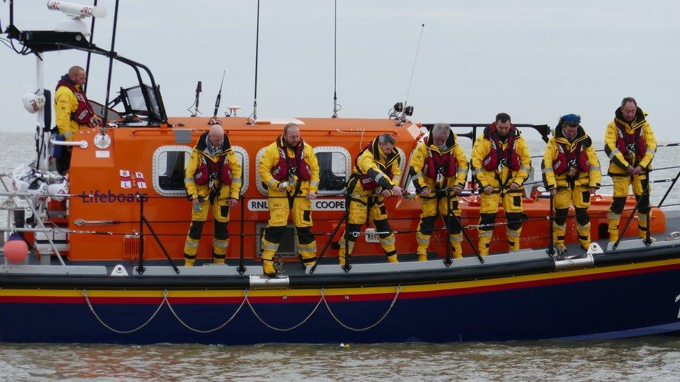 The lifeboat crew drop flowers into the sea