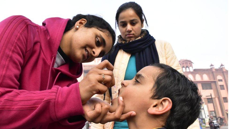 Health workers administer polio drops to a child during the National Immunization Day, on January 19, 2020 in Amritsar, India.