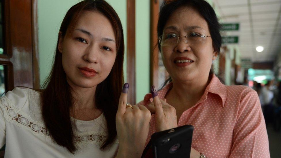 Two women with inked fingers after voting in Yangon