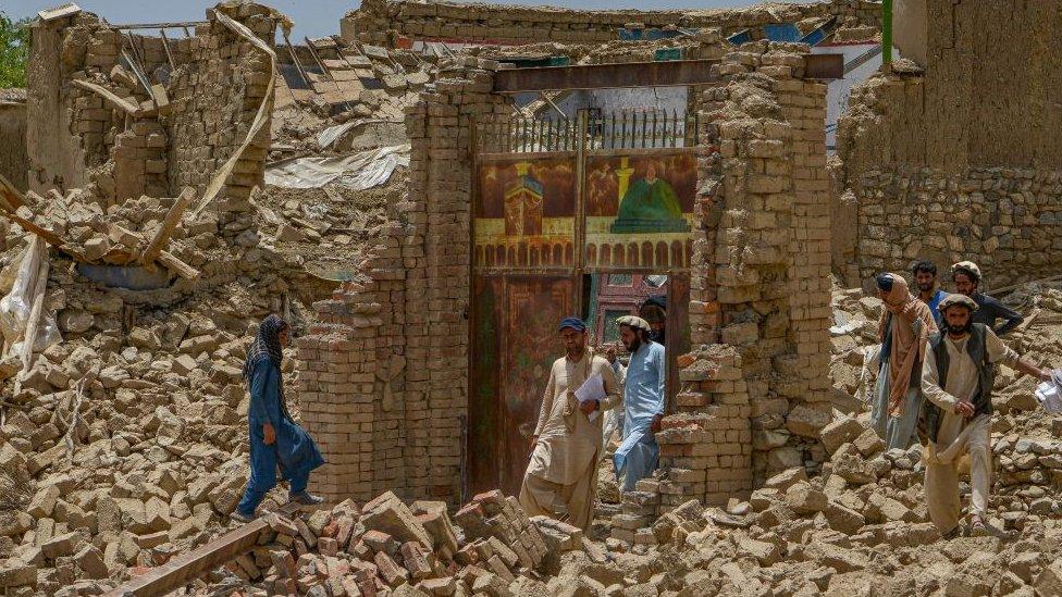 Image shows rescue workers examining extent of rubble