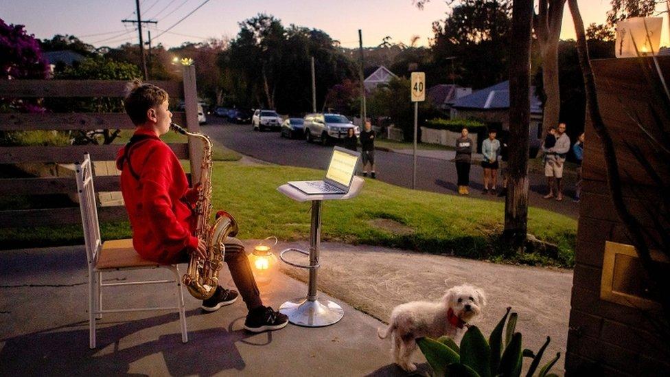 Jude Fell, aged 10, plays The Last Post on a saxophone from his driveway at dawn in Sydney on April 25, 2020