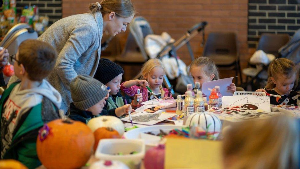 A group of five children painting Halloween pictures