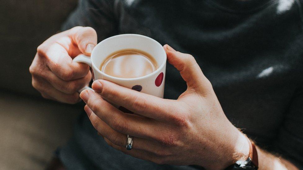 Man holding a cup of tea - generic