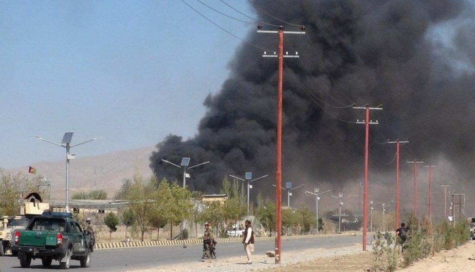 Smoke rises from police headquarters while Afghan security forces keep watch after a suicide car bomber and gunmen attacked the provincial police headquarters in Gardez, the capital of Paktia province, Afghanistan, on 17 October, 2017.