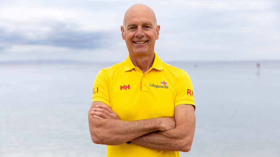 Mr Greenslade standing in his RNLI uniform with arms crossed