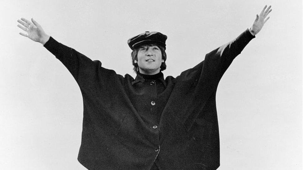 John Lennon of "The Beatles" poses for a photo in the snow in March 1965.