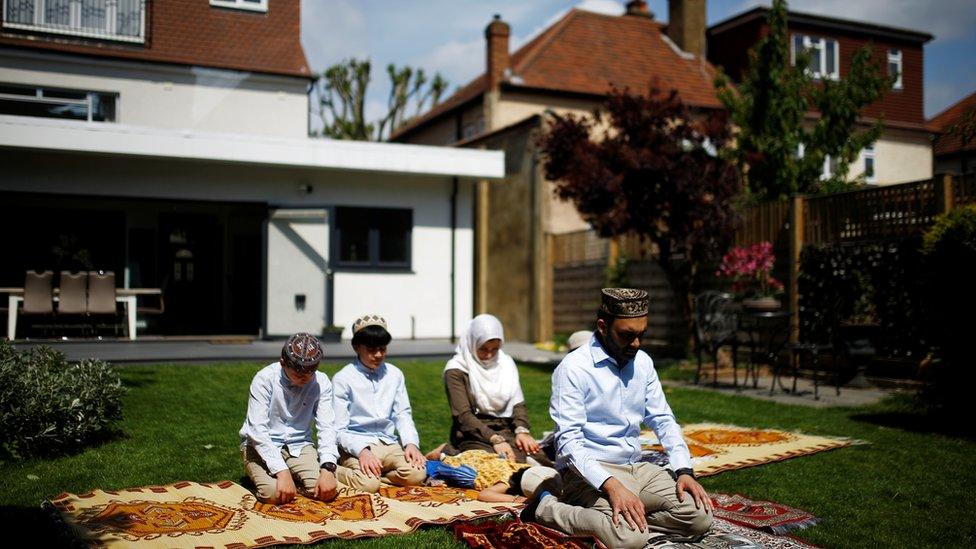 A family perform Eid prayers at home during the coronavirus pandemic