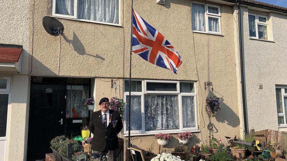 Glyn Sherman outside his home with the Union Jack at half mast