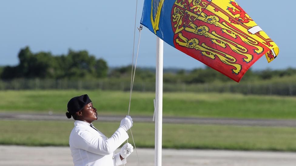 A flag is raised during a royal visit to Antigua in 2017