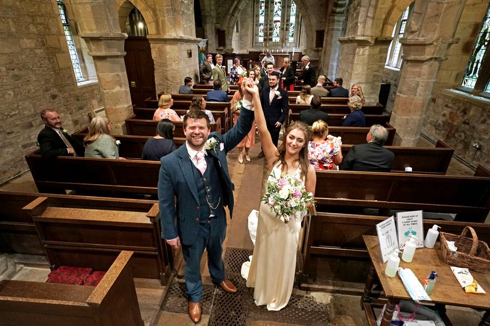 A wedding couple pose in a church